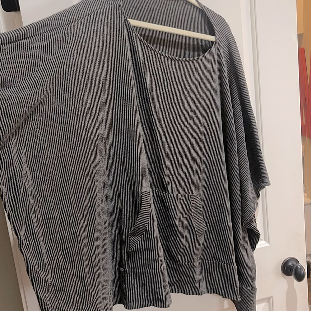 Poncho style sweater with front pocket and ribbed material